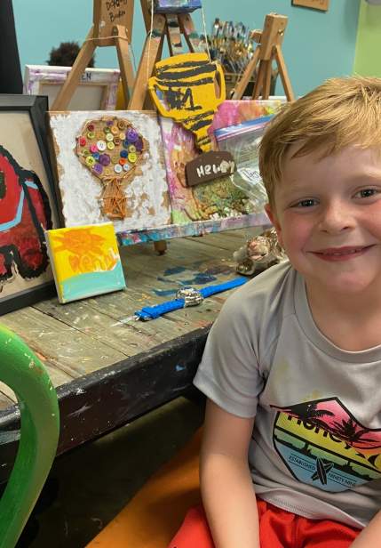 boy in a studio with painted items