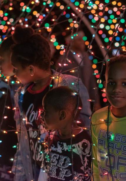 kids looking through a Christmas light display