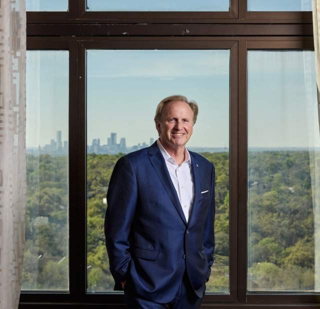 Rob Gillette wearing a blue suit smiling into the camera posing for a headshot.