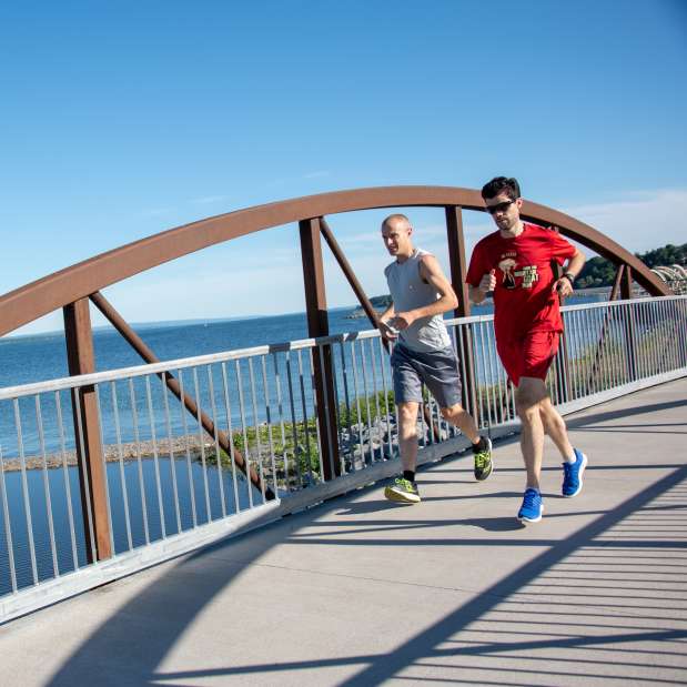 Two men running over a bridge near Seneca Lake