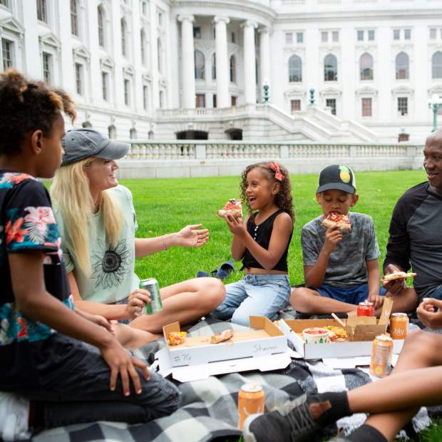 A family enjoys a picnic on the lawn of the Wisconsin State Capitol, one of Madison's most popular attractions