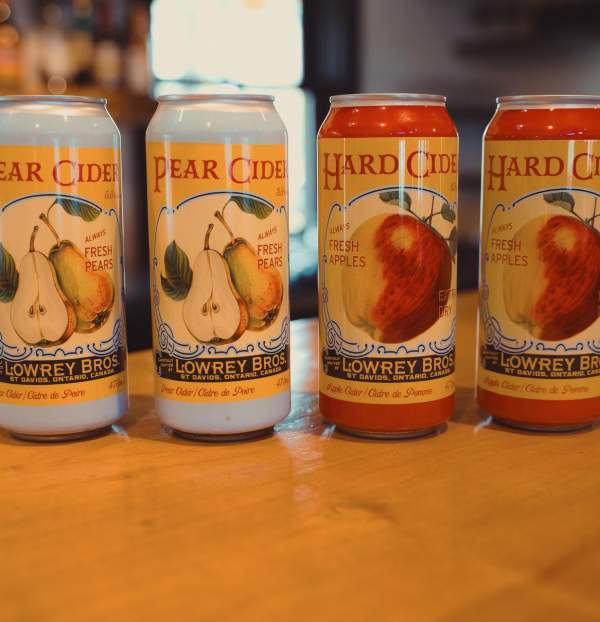 Four cans of cider sitting on a countertop