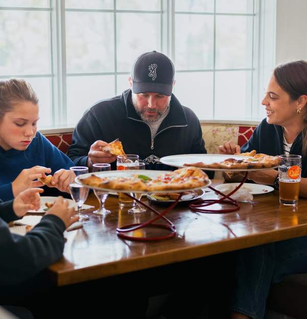Family sharing pizza at a diner booth