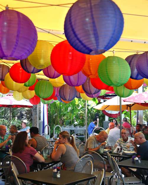 Sunday brunch outdoors. Red, purple, yellow, green, and orange sky lanterns hang from a canopy above the patrons.