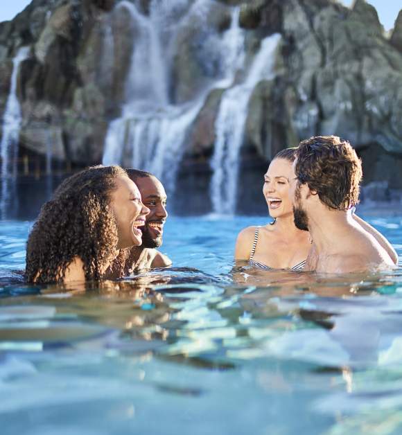 Two couples laughing in the water at Universal's Volcano Bay