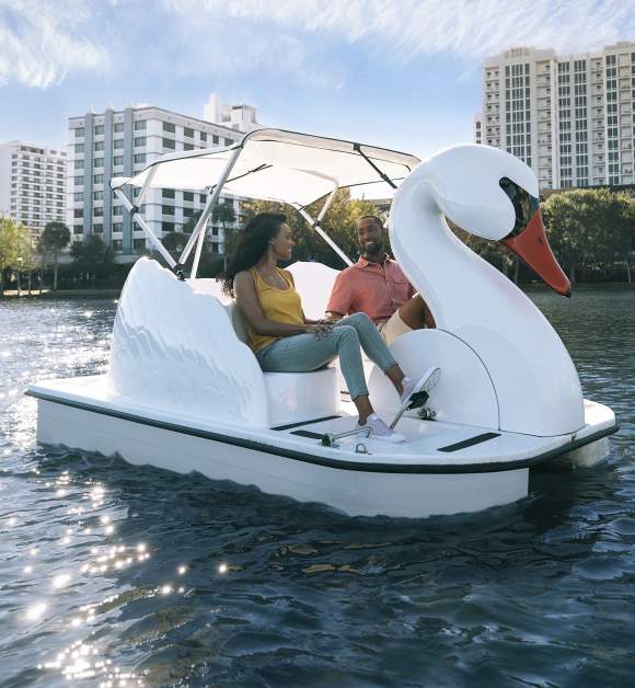 Couple exploring Lake Eola on a swan boat