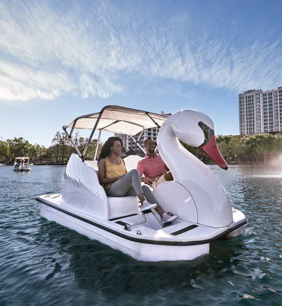 A couple exploring Lake Eola on a swan boat