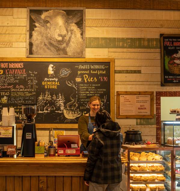 View of cafe with treats in the cabinet and art of a sheep on the walls