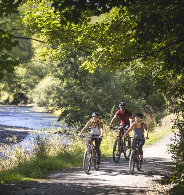 Friends biking alongside the Arrow River, Arrowtown