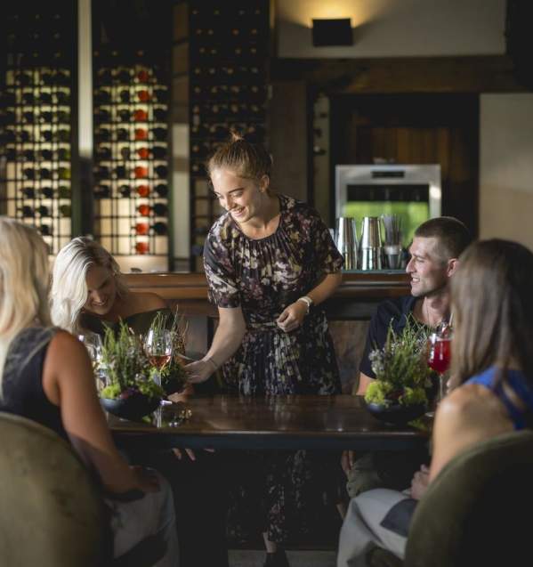 A waitress serving a group of diners at Amisfield Restaurant
