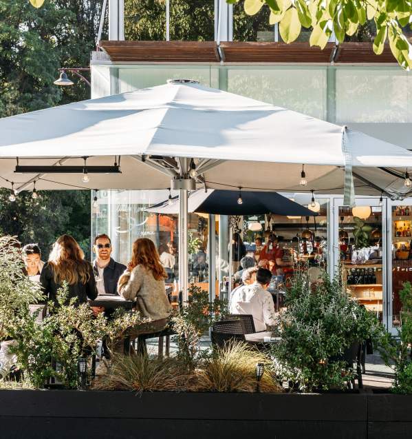View of a people sitting in a cafe courtyard surrounded with greenery