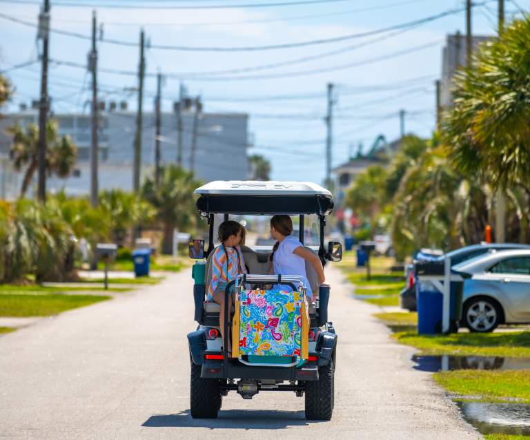 A golf cart cruises down the street in Cherry Grove