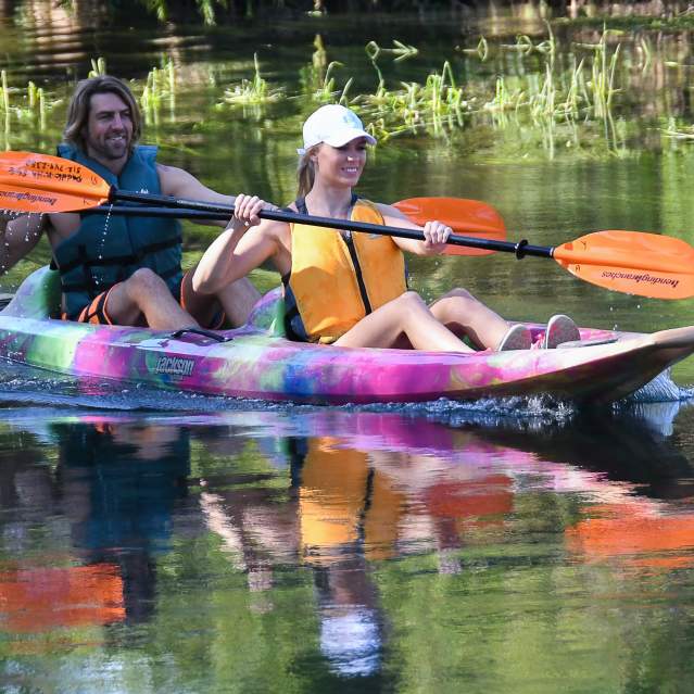 Couple in kayak paddling river