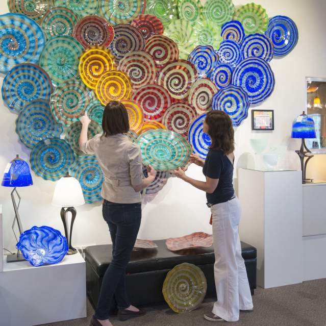 Two women looking at glass platters