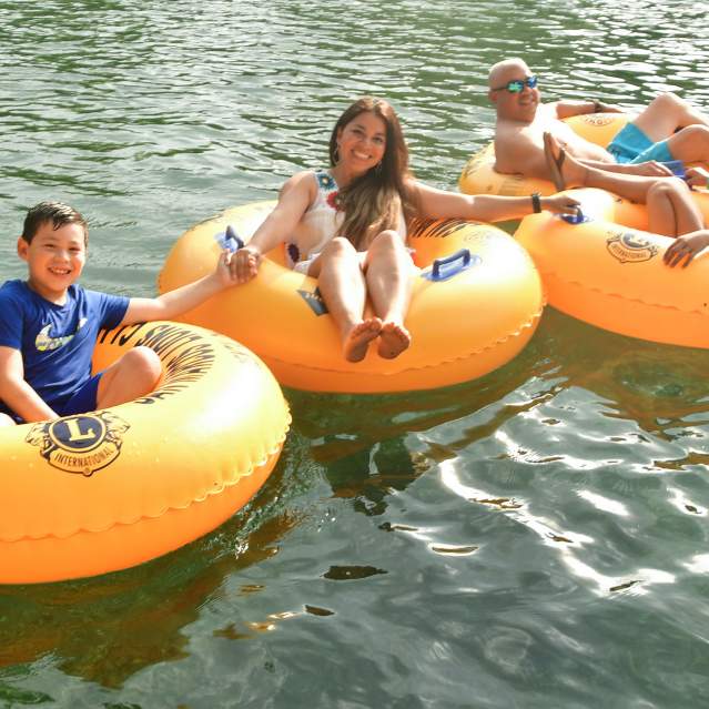Family with two kids tubing on river