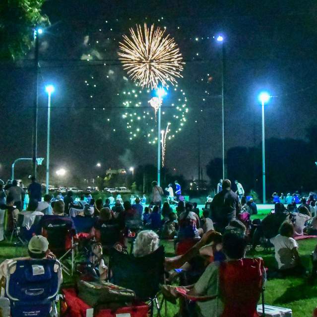 Fireworks with people in park watching