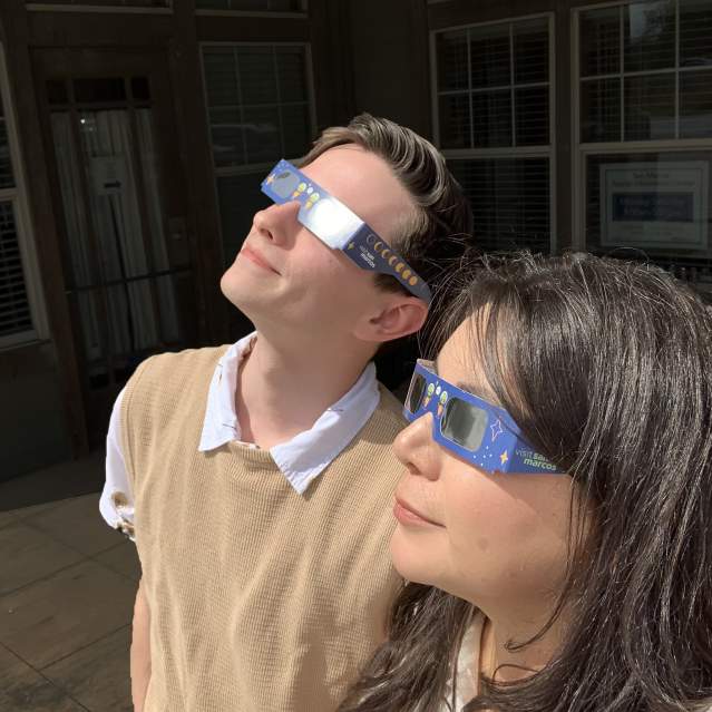 Denise and Jared stare at the eclipse with their snazzy eclipse glasses on in San Marcos, Texas