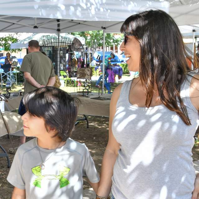 Mom and son looking at booths at art market