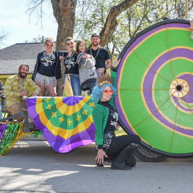 A group of Mardi Gras attendees strike a pose on the parade route in San Marcos, TX