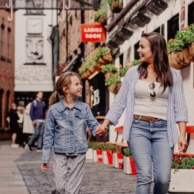 Mother and daughter holding hands walking through Commercial Court in Belfast