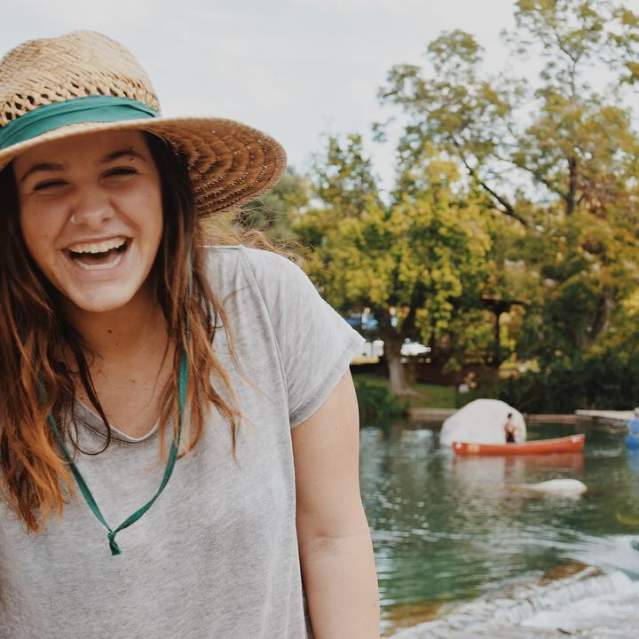 Girl laughing at camera in Rio Vista Park in San Marcos, Texas