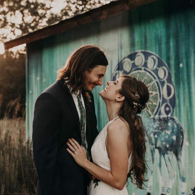 Wedding couple looking dreamily at each other outdoors