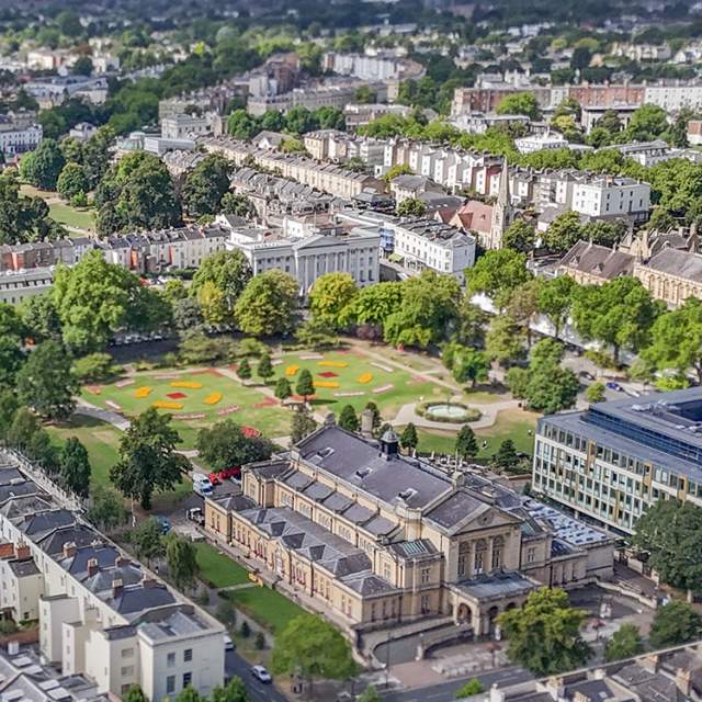 Aerial view of Cheltenham Town Hall and Imperial Gardens, Cheltenham and surrounding areas of the town.