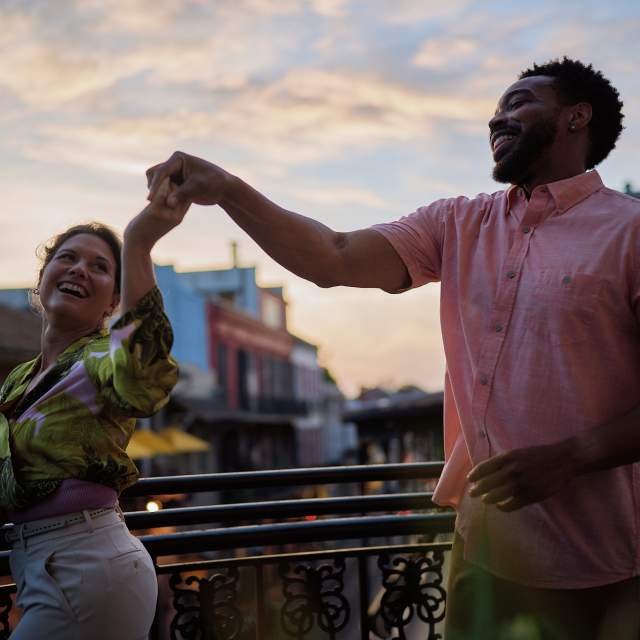 A couple dances on a French Quarter balcony