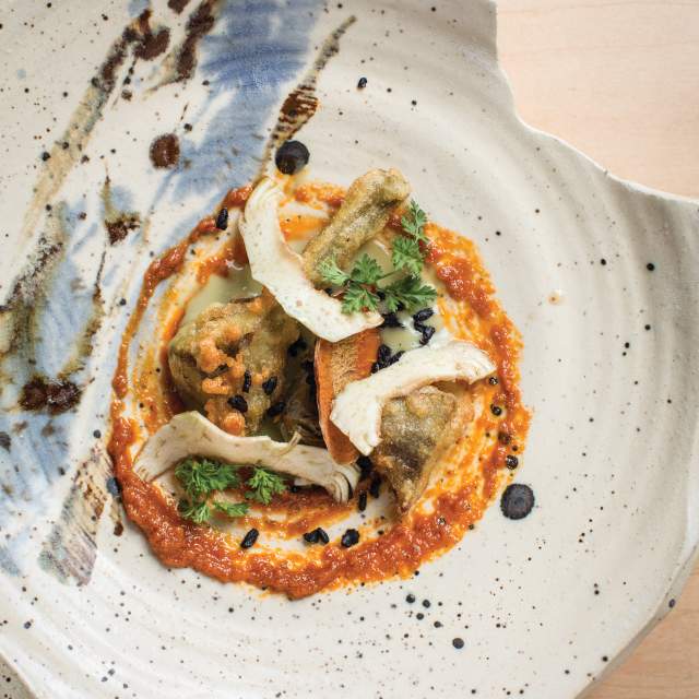 an artfully plated dish of food on a splattered organic-edged plate