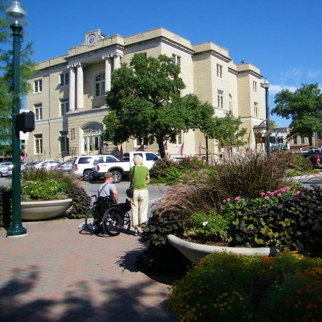Person standing and person in wheelchair at crosswalk on Louisiana Street