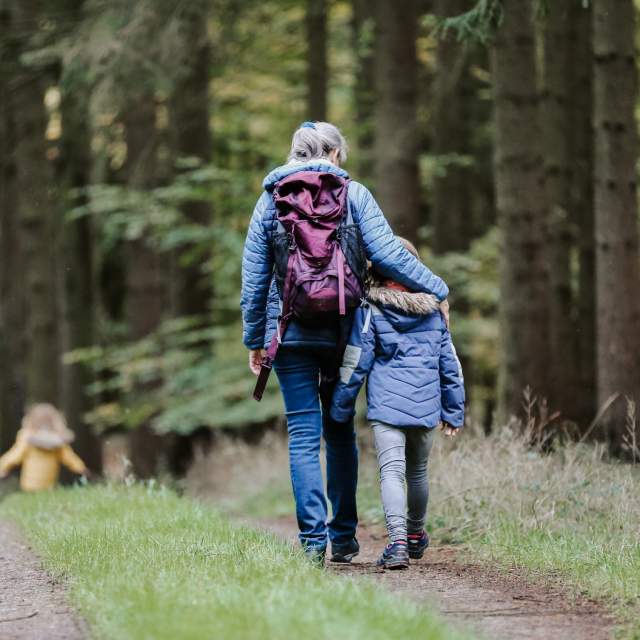 Familie som går tur i skogen