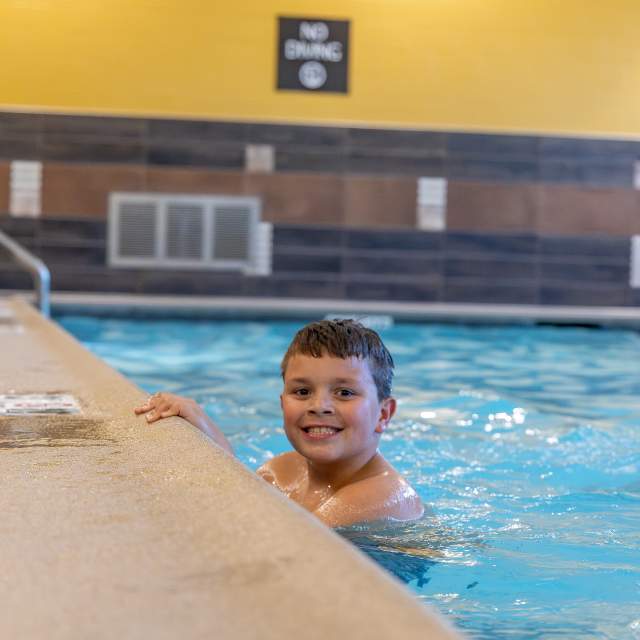 Boy swimming in pool at Homewood Suites in Salina, Kansas