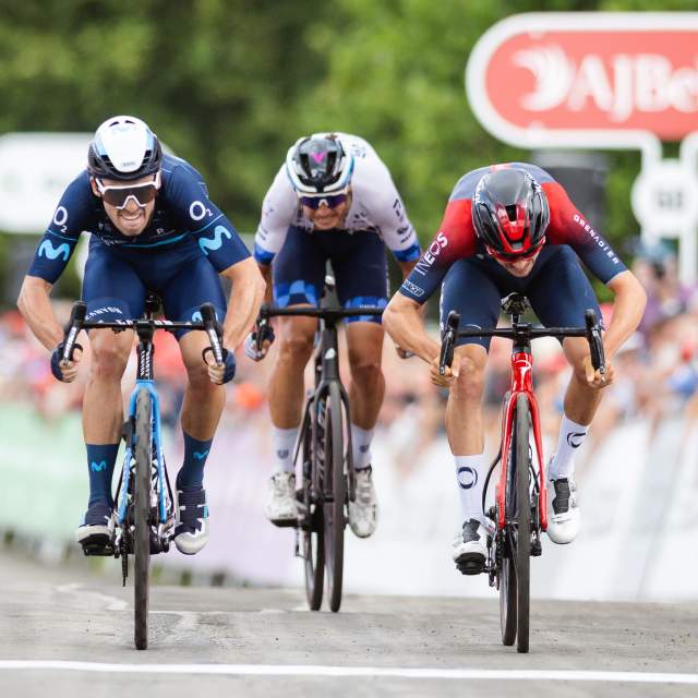 Three cyclists approach the finish line during the Tour of Britain race, riding towards the camera.