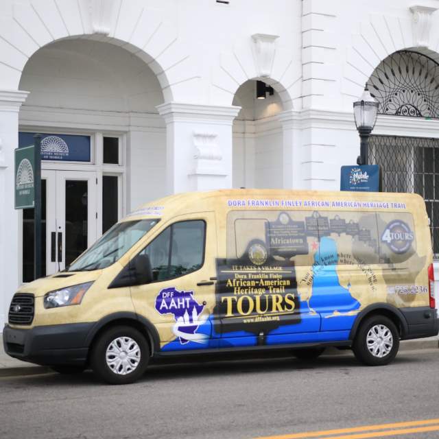 colorful passenger van parked in front of white building