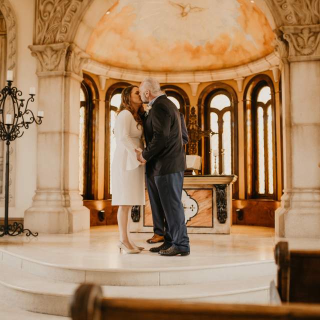 Bride and groom kissing on the altar at the Bella Donna Chapel
