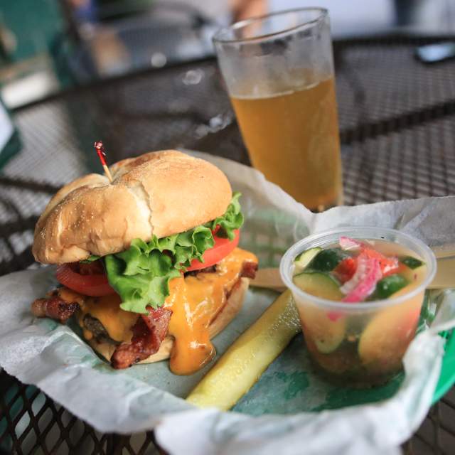 Bacon Cheeseburger, pickle spear, cup of tomato and cucumber salad