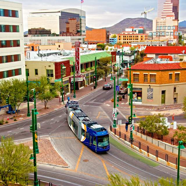 Blue and yellow streetcar riding through downtown Tucson