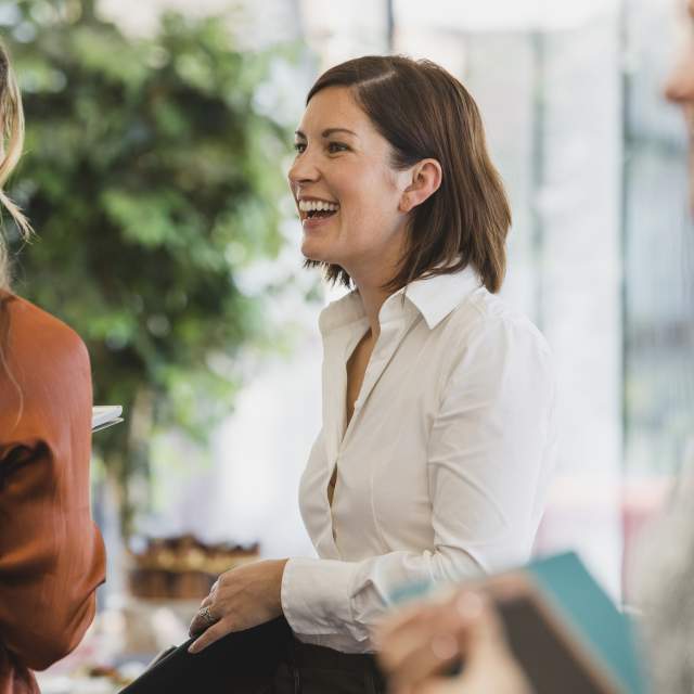 Smiling businesswoman at work seminar, networking, confidence, conversation