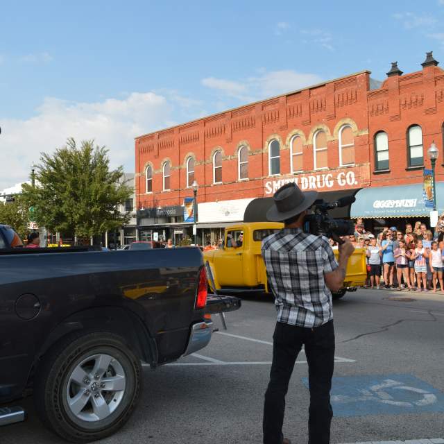 Film crew filming a staged parade in downtown McKinney