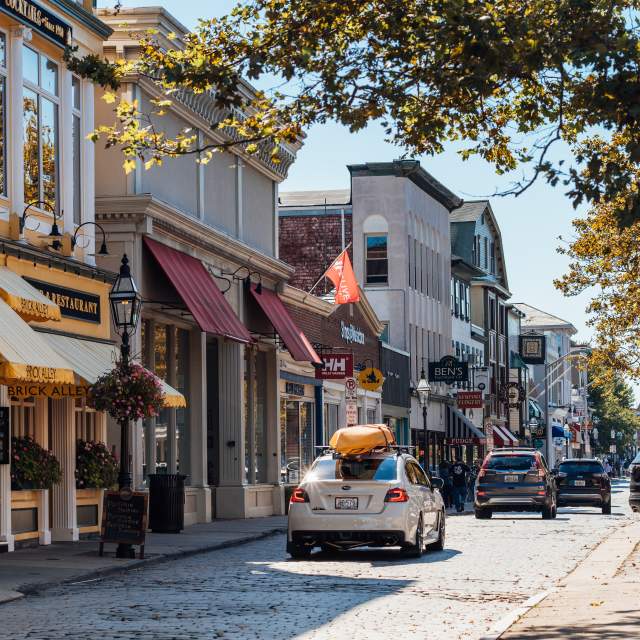 A cobblestone street with historic buildings and storefronts