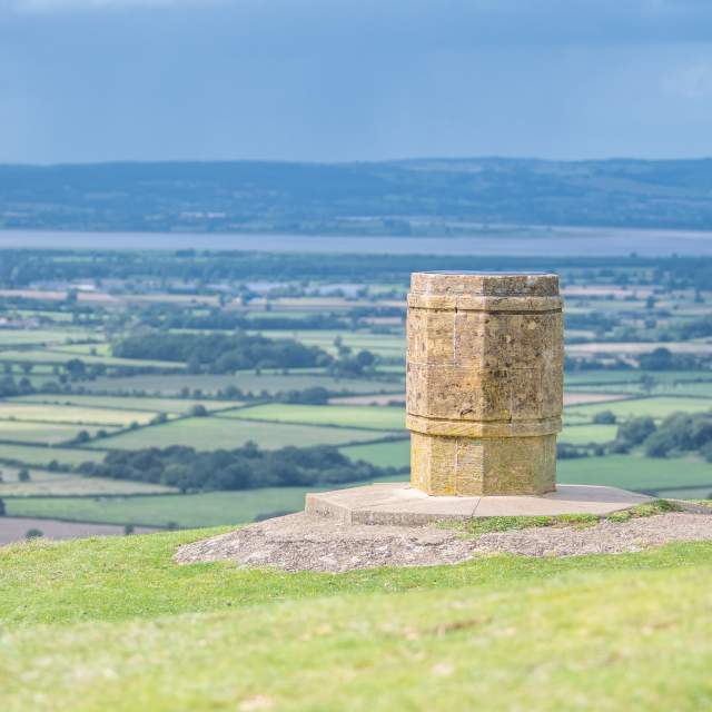 View from Nympsfield Long Barrow looking down from the Cotswold escarpment towards the River Severn and the Welsh mountains