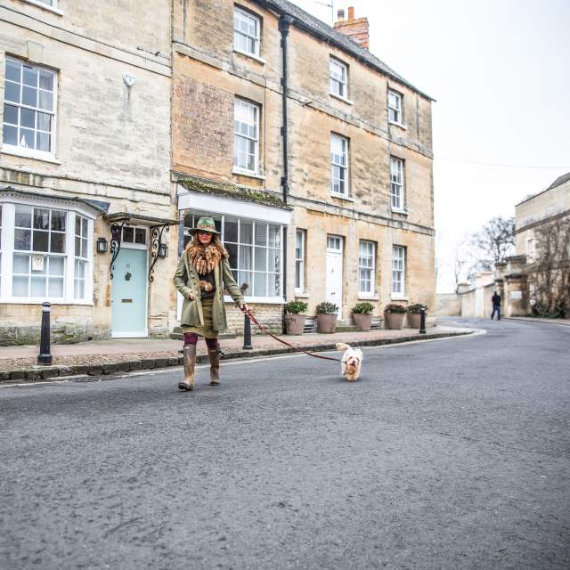 Woman wrapped up warmly taking her dog for a walk in Woodstock
