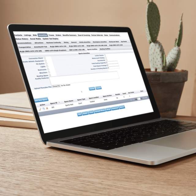 The interface of the CRM Sports User Group module displayed on a laptop computer sitting on a desk next to a cactus.