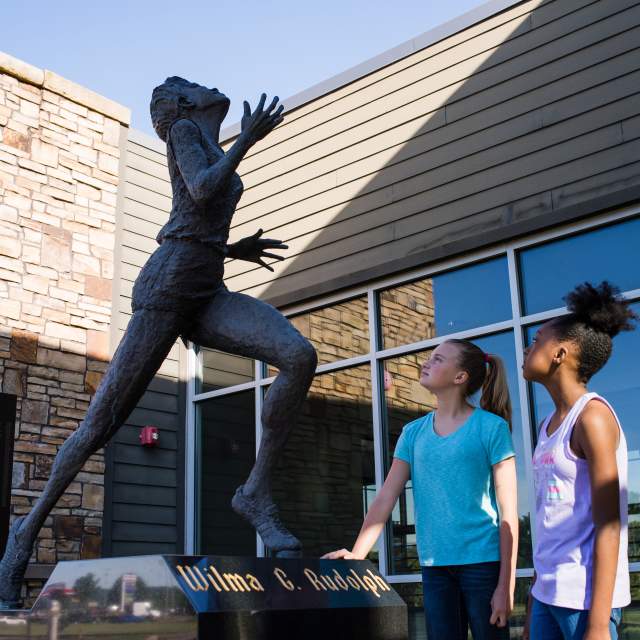 two girls admire the Wilma Rudolph statue