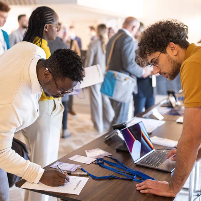 Business conference participants registering for a conference in the lobby of a hotel