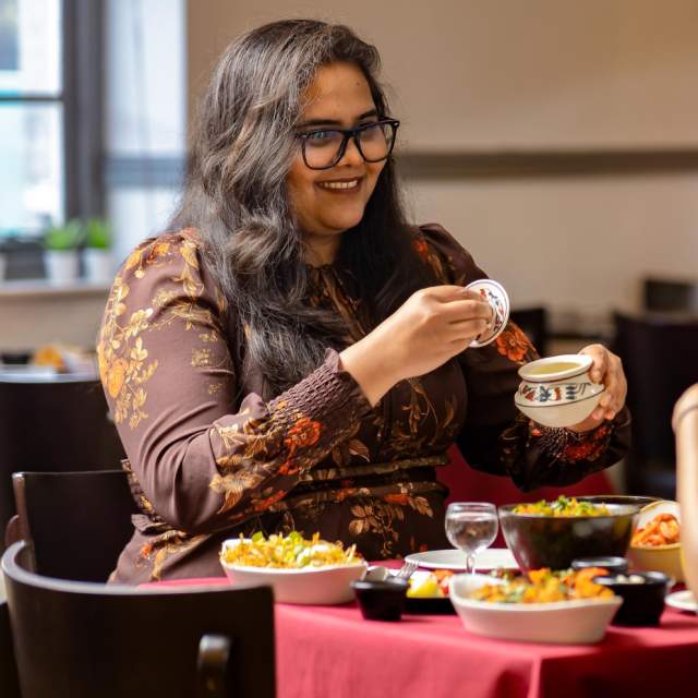 Two people sat opposite each other eating at Mint Dosa