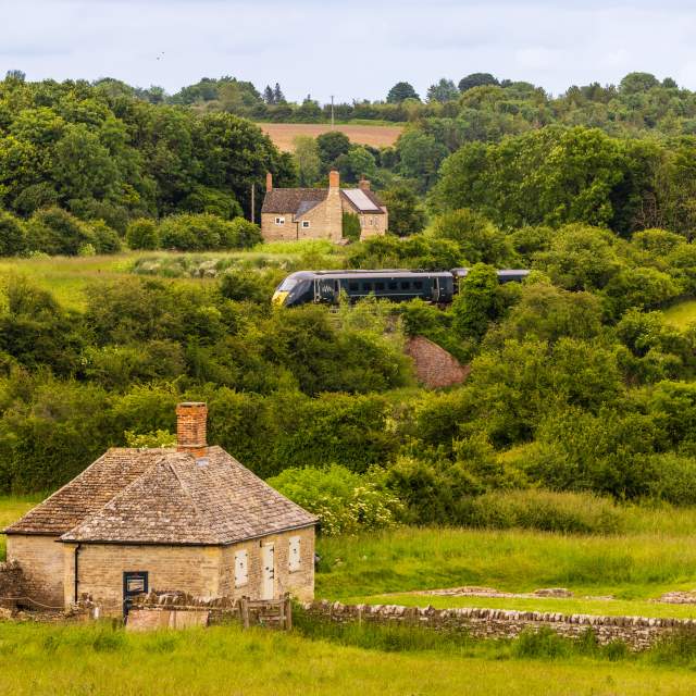 A view of North Leigh Roman Villa with a GWR train passing in the distance behind