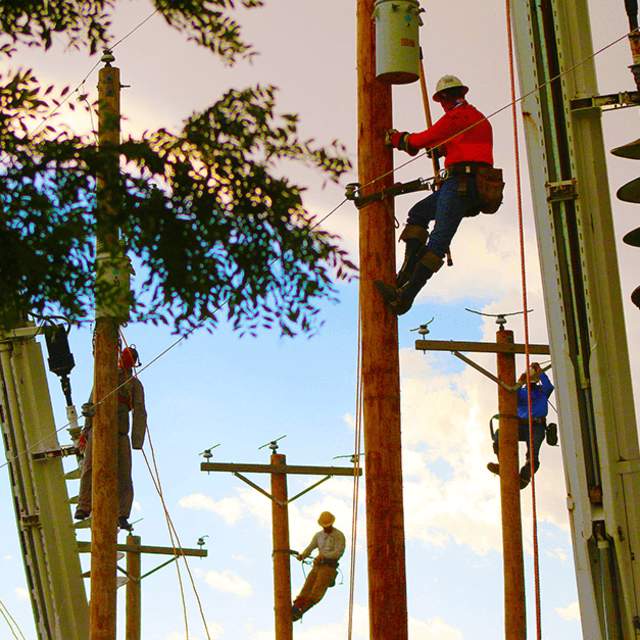 Lineman climbing a pole to fix a powerline