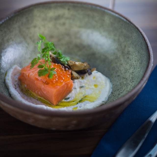 Plate of food at Pausa with a glass of wine