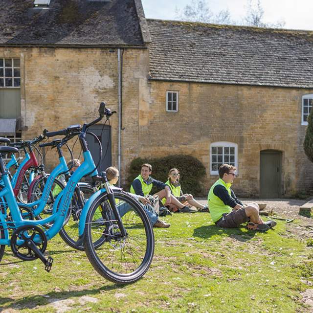 A group of cyclists sitting by a pond
